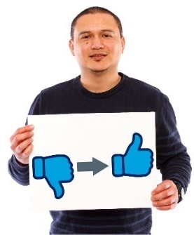 A man holding a sign. There is an arrow pointing from a thumbs down to a thumbs up