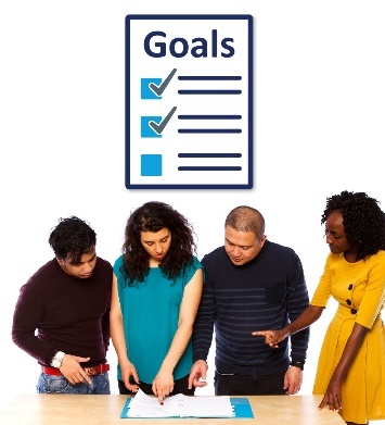 A group of people reading a document and a list of goals. 