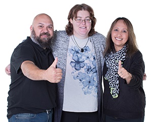 A group of people smiling and giving a thumbs up. 