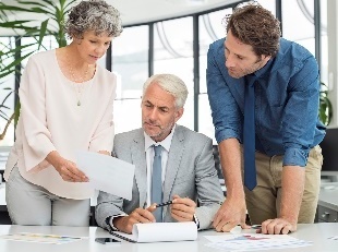 A group of people reading a document.