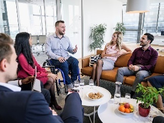 A man in a wheelchair talking to a group of people.