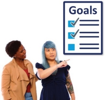 A woman supporting another woman, who is pointing at a list of goals.